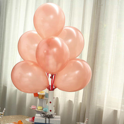 Pink balloons on a white table with a light backdrop.