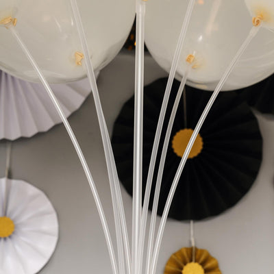 Clear balloons with transparent strings, surrounded by decorative fans.