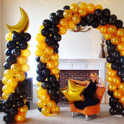 Decorative black and gold balloon arch with a star-shaped balloon.