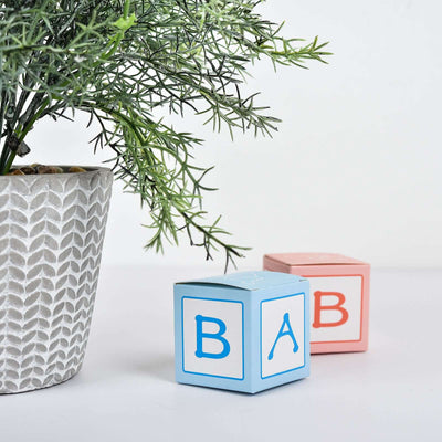 Colorful baby blocks next to a decorative plant in a modern pot.