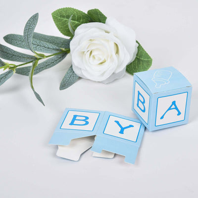Blue baby blocks with letters, next to a white rose.