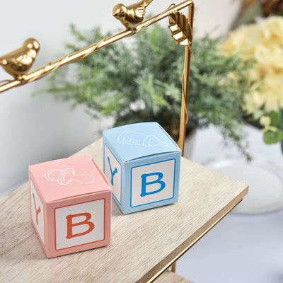 Colorful baby blocks in pink and blue on a wooden shelf.