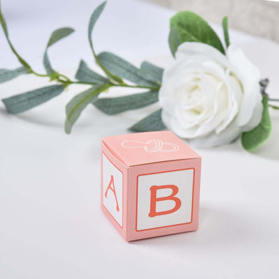 Pink alphabet block with letters A and B, surrounded by a floral arrangement.