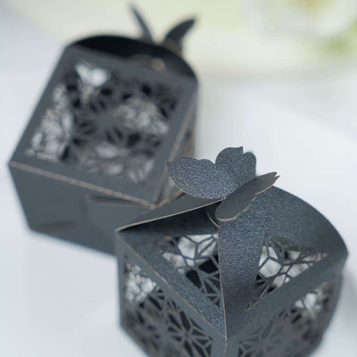 Black decorative gift boxes with intricate cutout designs.