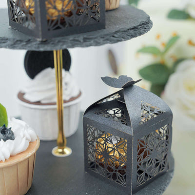 Decorative black lanterns with treats on a tiered cake stand.