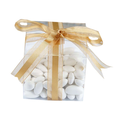 Clear gift box filled with white candies and gold ribbon