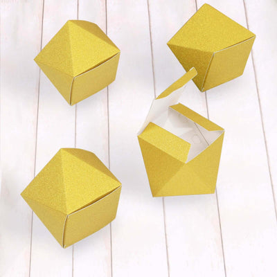 Gold geometric gift boxes on a wooden surface.