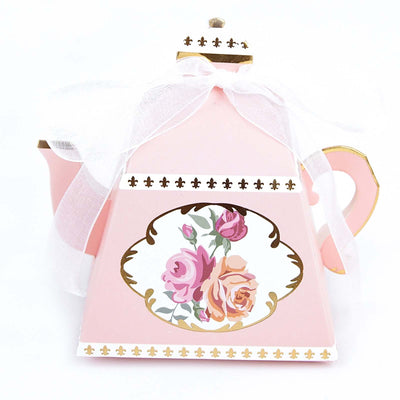 Pink teapot with floral design and ribbon bow on white backdrop