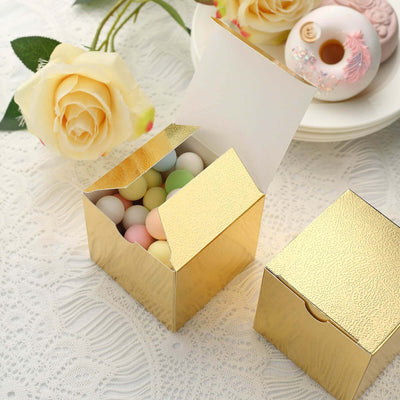 Gold gift box filled with pastel candies on a lace tablecloth.