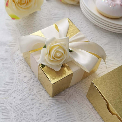 Elegant gold gift box adorned with a white rose and ribbon.