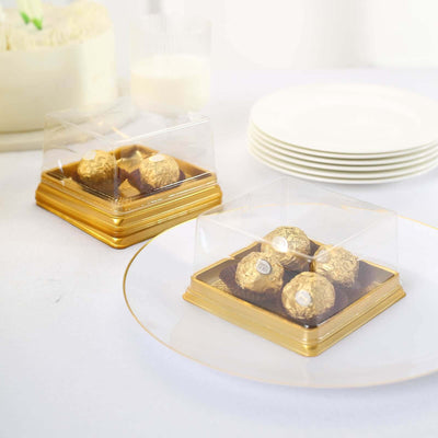 Gold-wrapped chocolates in clear boxes on elegant plates.