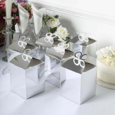 Silver gift boxes with elegant bows on a table with flowers.