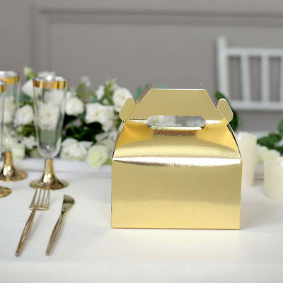 Gold gift box on a table set with elegant decor and floral arrangements.