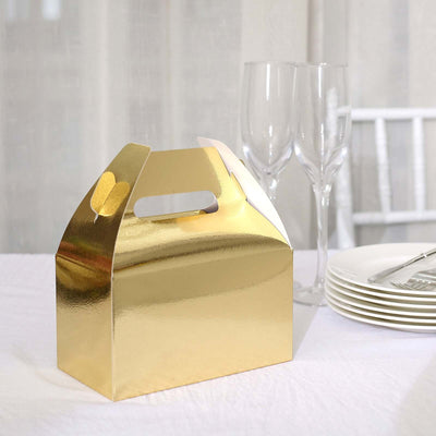 Gold takeaway box on a dining table with glasses and plates.