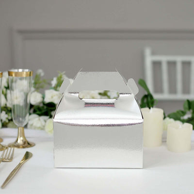 Silver takeaway box on a table with floral decor and candles.