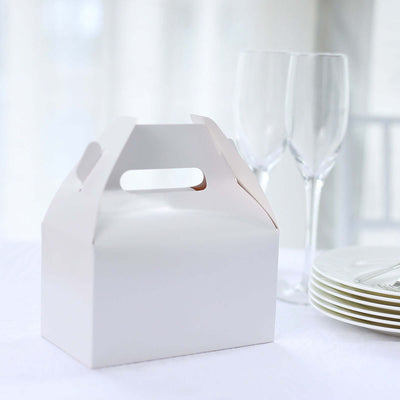 White takeaway box on a table with champagne flutes and plates