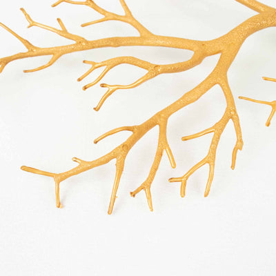 Gold decorative coral branch on a plain background.