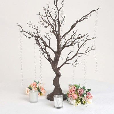 Decorative tree centerpiece with hanging crystals and floral arrangements