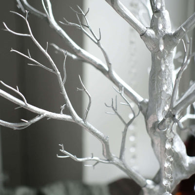 Silver decorative tree with intricate branches and beads.
