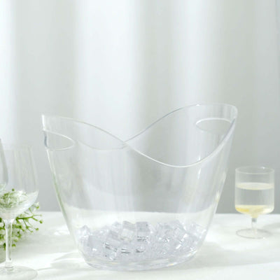 Clear ice bucket with handles, filled with ice cubes.