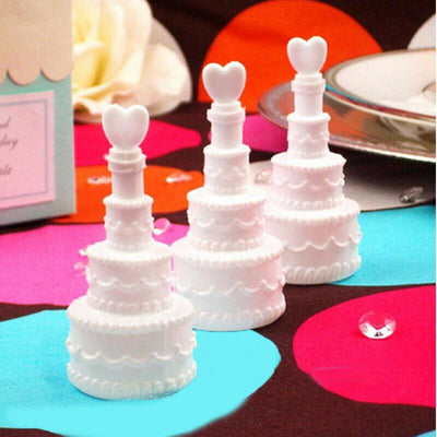 White wedding cake decorations with heart toppers on a colorful background.