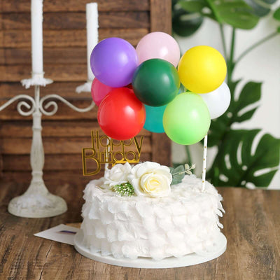 Birthday cake with colorful balloons and a flower decoration.