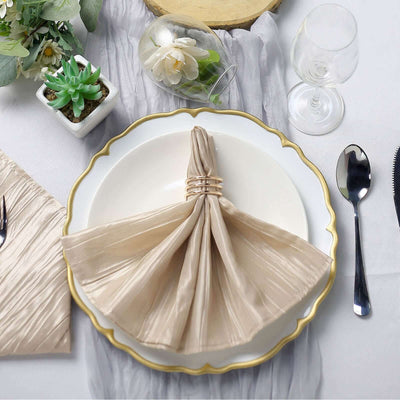 Elegant beige napkin with gold ring on a decorative plate, styled table setting.