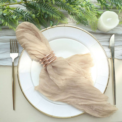 Elegant beige napkin with rose gold napkin rings on a stylish plate setting.