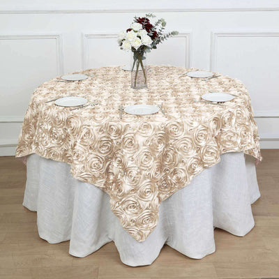 Rose-patterned tablecloth draped over a round table with plates and a vase of flowers.