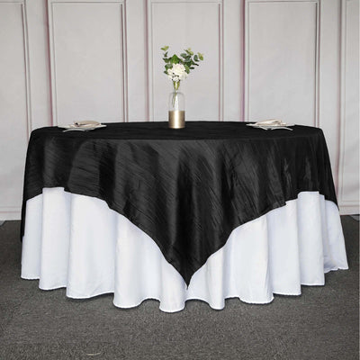 Black tablecloth draped elegantly over a round table with a white undercloth.