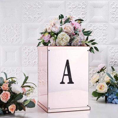 Floral arrangement in a mirrored box with letter "A" against a textured white background.