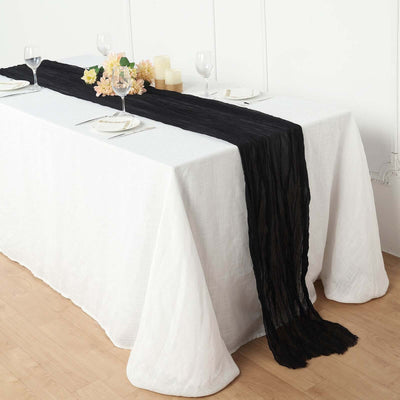 Black table runner draped elegantly over a white table setting.