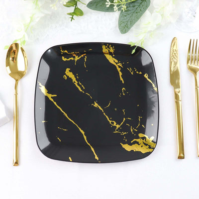 Black square plate with gold marbling design, styled with gold cutlery.