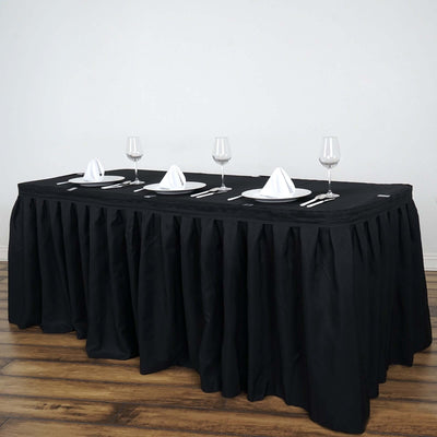 Elegant black tablecloth draped over a banquet table set with dinnerware and glassware.