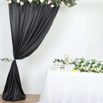 Black drapery and floral arrangement on a table for event decor.