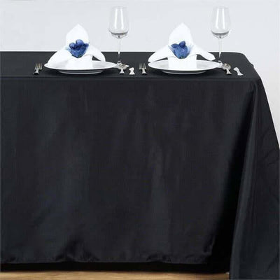 Elegant black tablecloth set for dining with napkin decor and glassware.