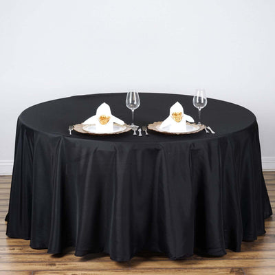 Elegant black tablecloth with gold-accented dinner setting for two.