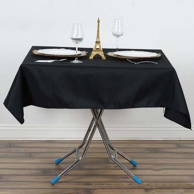 Elegant dining table set with Eiffel Tower centerpiece and wine glasses.