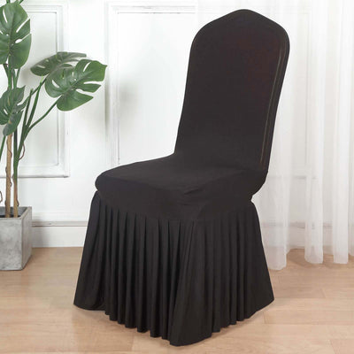 Black fitted chair cover with pleated skirt in a stylish setting.