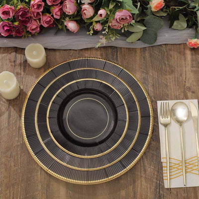 Elegant black and gold charger plate set on a rustic wooden table with floral decor.