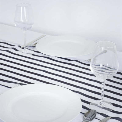 White dinner plates and elegant wine glasses on a striped table runner.