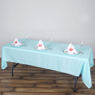 Elegant turquoise tablecloth set for dining with napkins and glassware.