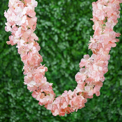 Pink floral garland on a green background.