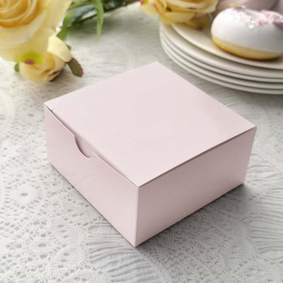 Pink gift box on a lace tablecloth with decorative items.