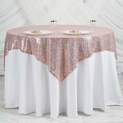 Rose gold sequin table overlay on a round white table with glassware.