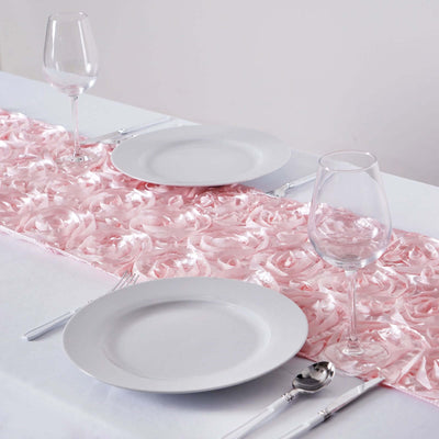 Pink rose table runner with white plates and glasses on a dining table.