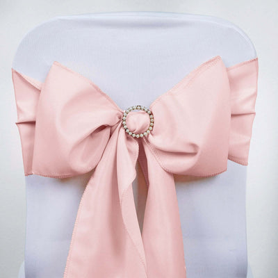 Pink chair sash with jeweled center bow against a plain backdrop.