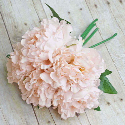 Pink peony flower bouquet on a wooden surface.