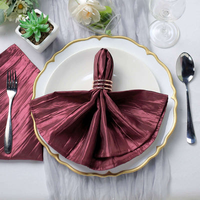 Elegant burgundy napkin elegantly arranged on a fine dining plate setting.