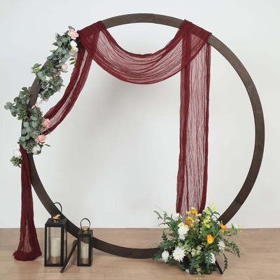 Decorative circular backdrop with fabric draping and floral accents.